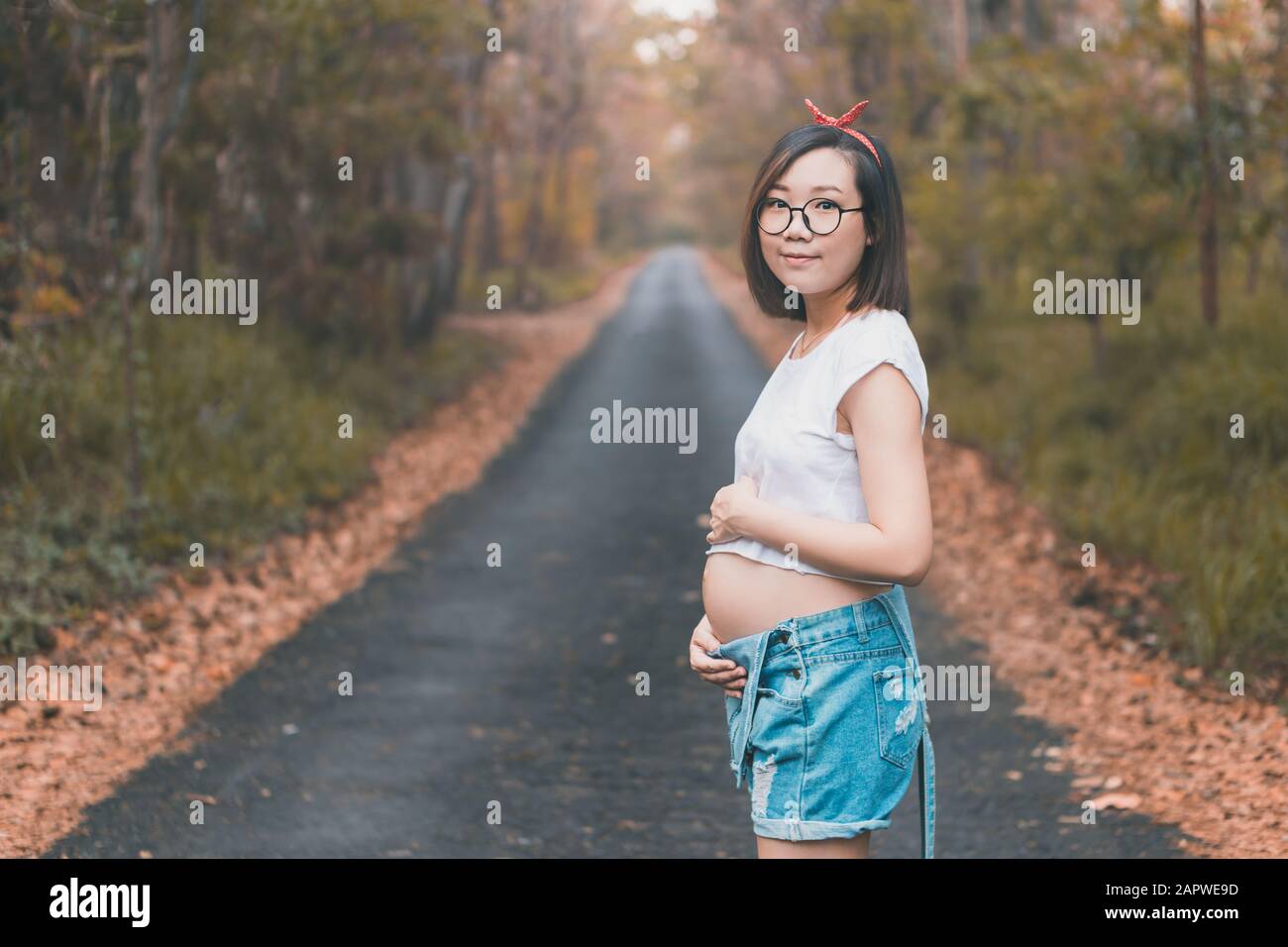 Young pregnant Asian woman wearing cute clothes and glasses Stock Photo