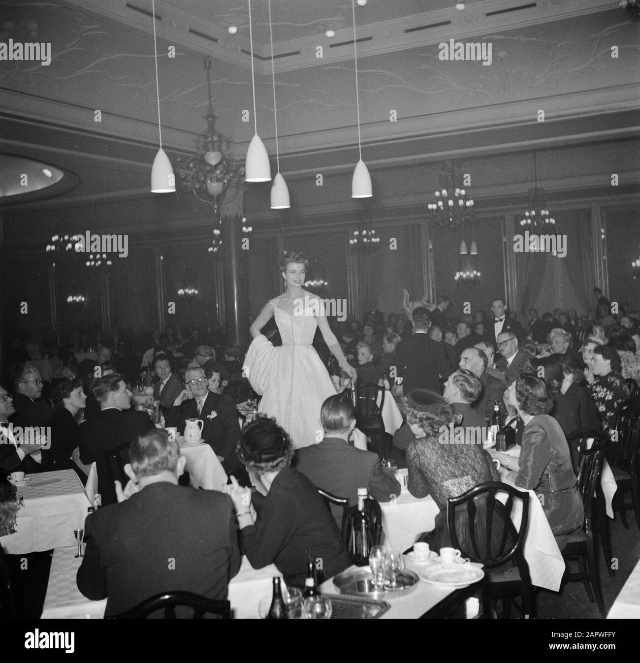 Restaurant Wivex located in the facade building of Tivoli park  Mannequins run a fashion show during a car show in restaurant Wivex Date: March 1954 Location: Denmark, Copenhagen Keywords: car s, fur, eaters, photo models, catering, dresses, clothing, furniture, fashion, audience, restaurants, crockery, exhibitions Institution name: Wivex Stock Photo