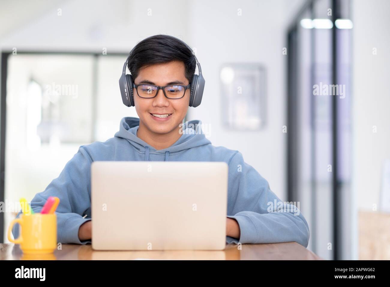 Young collage student using computer and mobile device studying online.  Education and online learning Stock Photo - Alamy