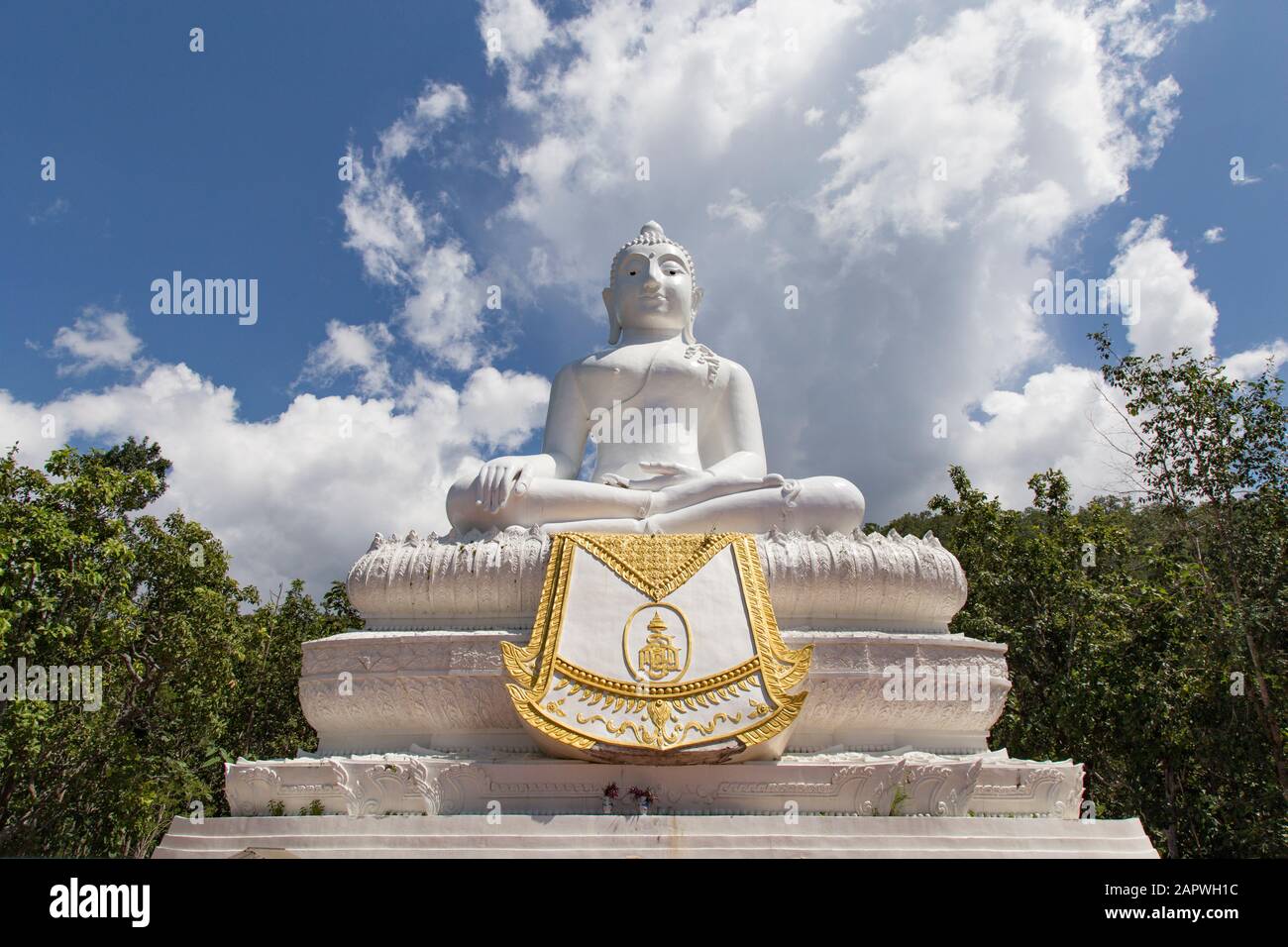Giant white Buddha statue under a blue sky with white clouds Stock