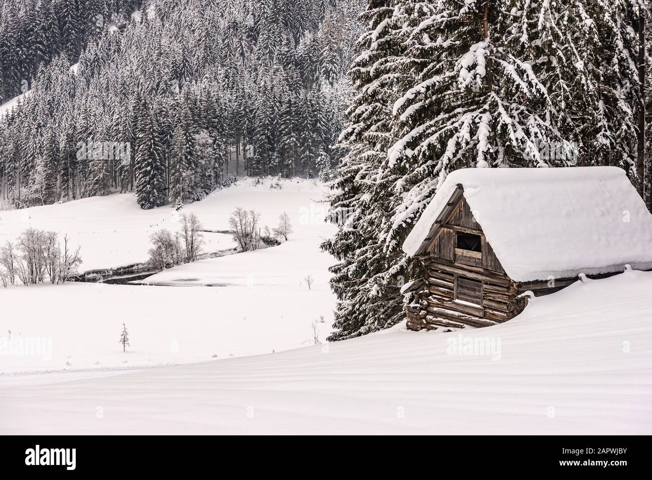 Wooden Mountain Shed Against The Backdrop Of Snowy Mountains And