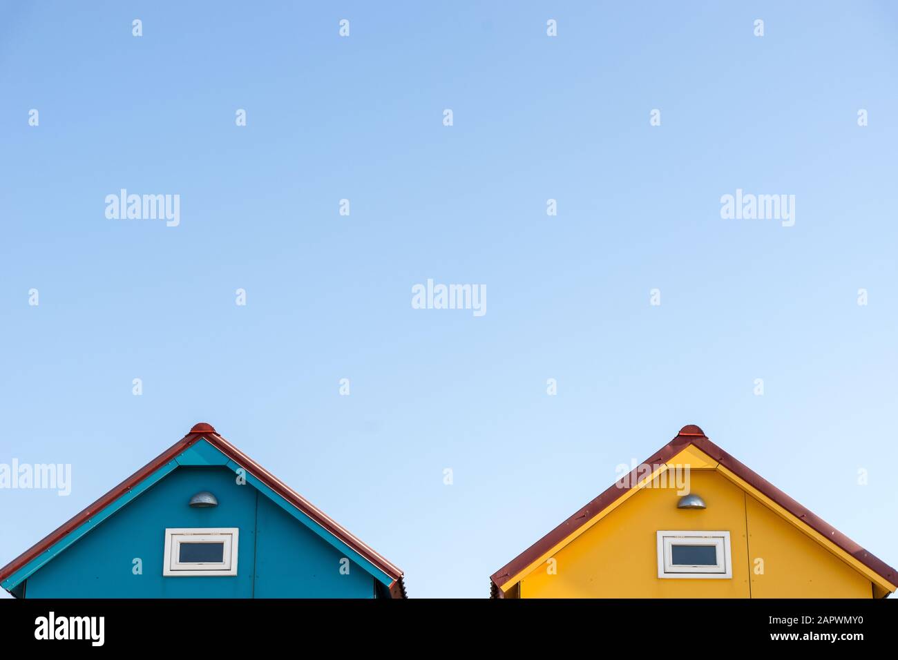 Roofs of small blue and yellow houses with a lightcolored background
