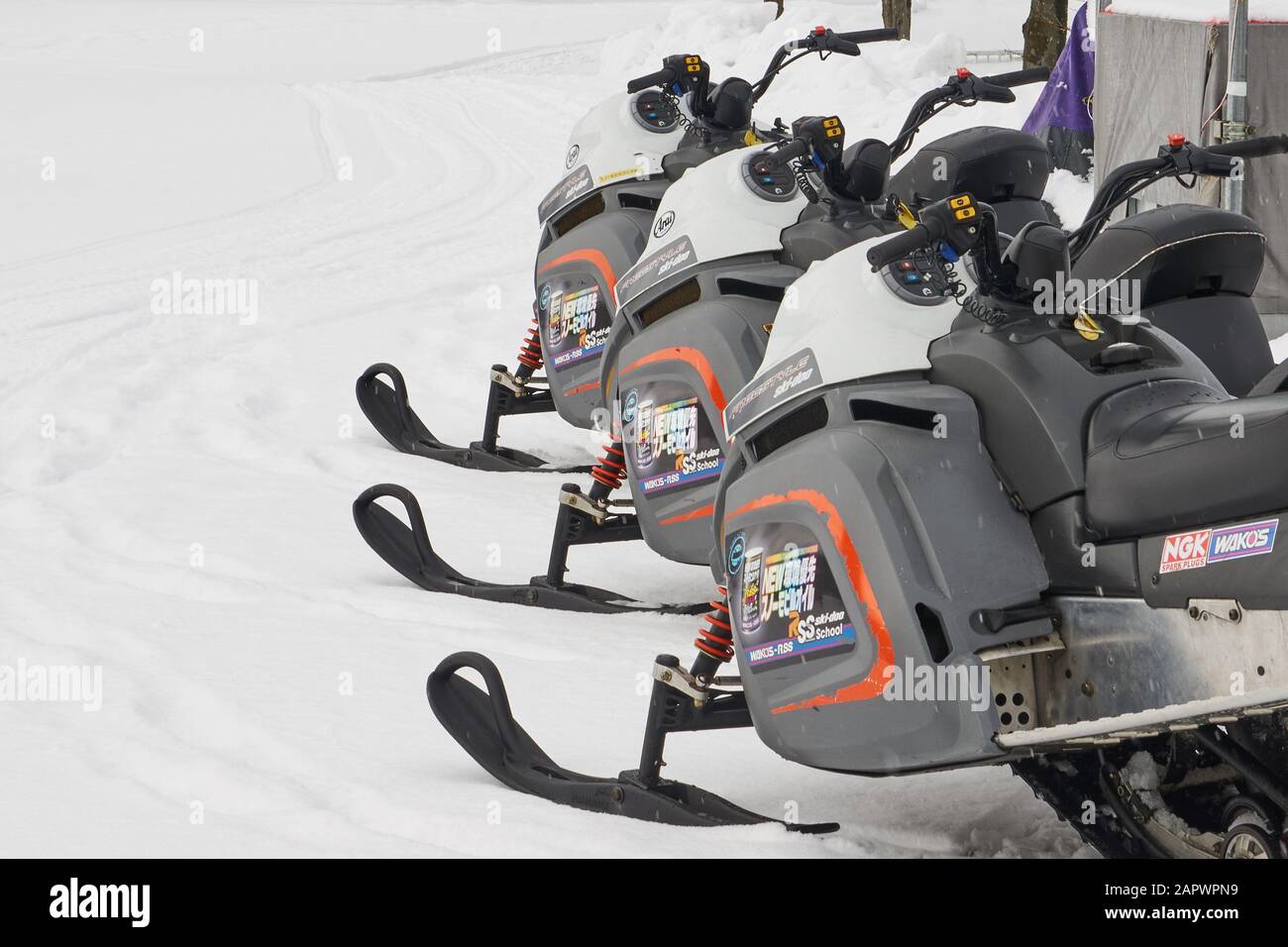 Three snowmobiles (snow machine, motor sled, motor sledge, skimobile,  snowscooter, sled or Ski-Doo) lined up on snow in Japan Stock Photo - Alamy