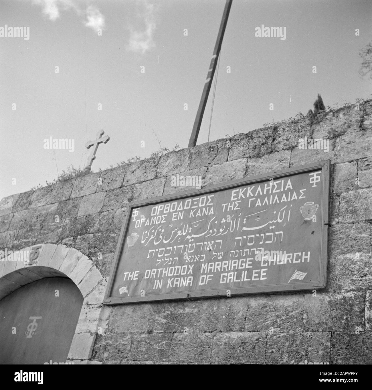 Israel 1948-1949: Cana  Name sign at the Greek Orthodox Church Wedding Church Annotation: The text on the board reads: The Orthodox Wedding Church in Cana (Galilee). The term Wedding Church refers to the miracle Jesus of Nazareth would have done, turning water into wine during the wedding of Cana Date: 1948 Location: Israel, Cana Keywords: church buildings, walls, nameplates Stock Photo