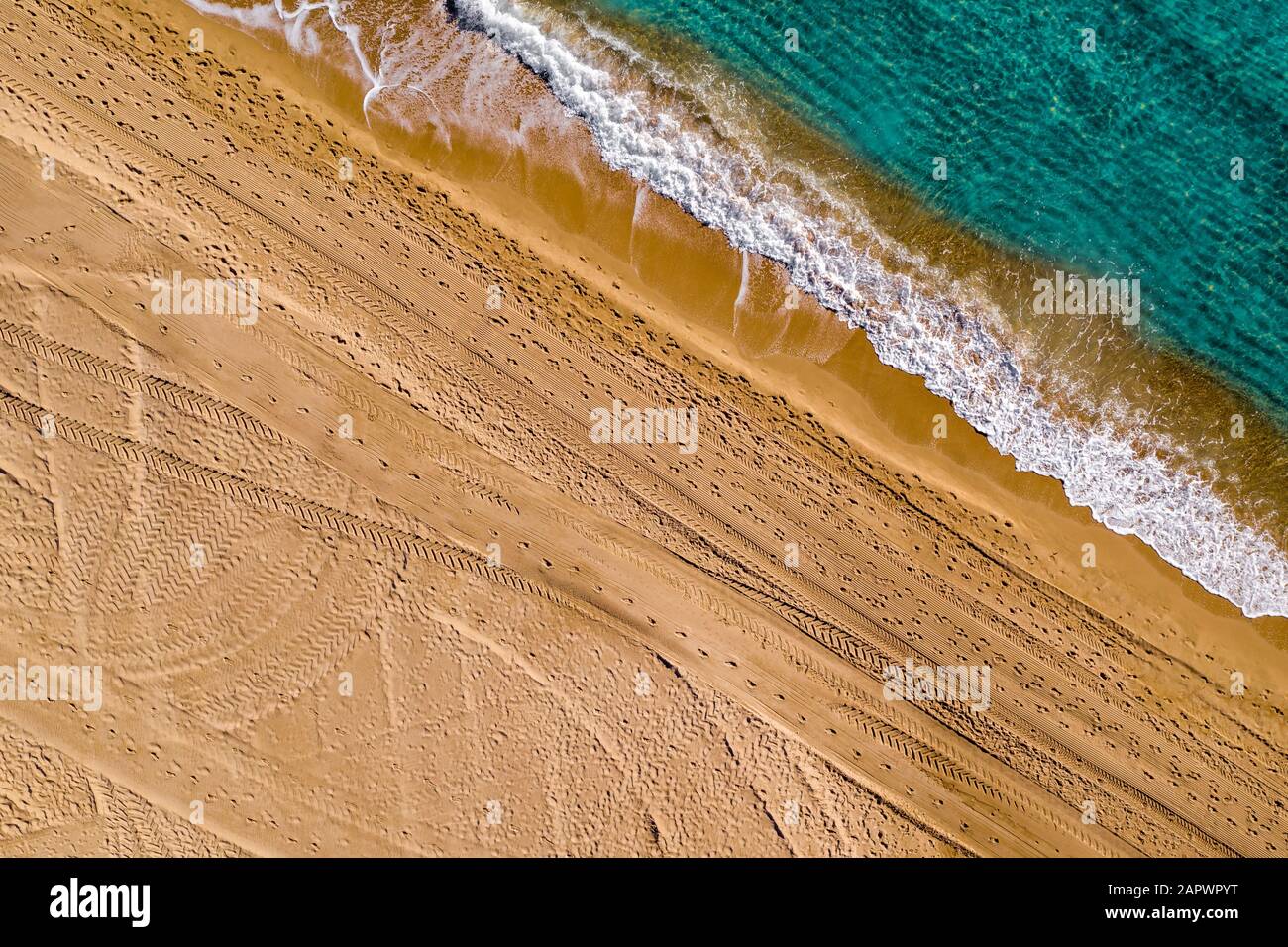 Aerial view of step marks and vehicle tracks in the sand on the beach of Alicante Spain with turquoise water Stock Photo