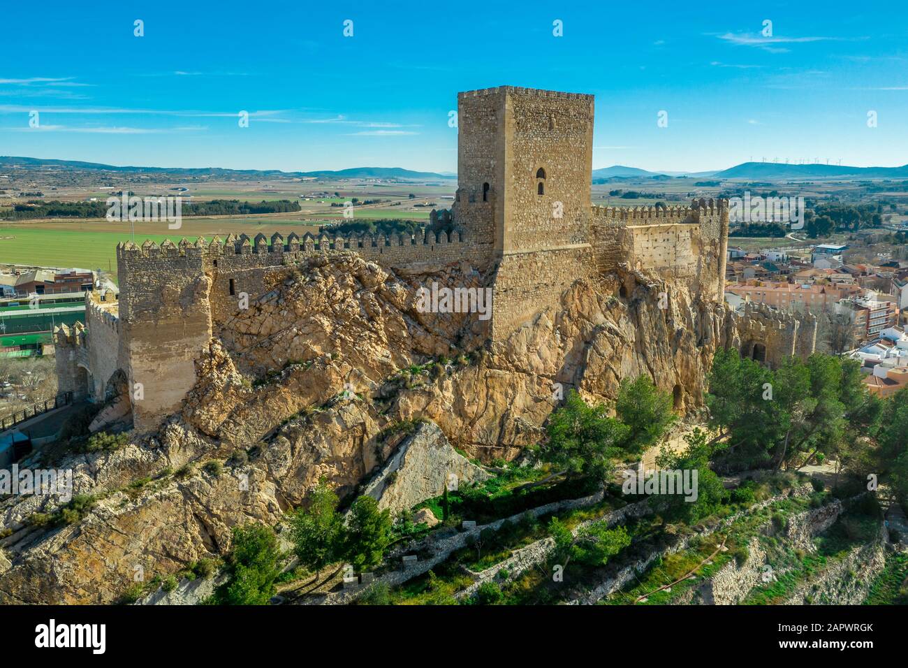 Aerial view of medieval Almansa castle with donjon and courtyard on a rock emerging from the plateau surrounded by a circular ring of red roof houses Stock Photo