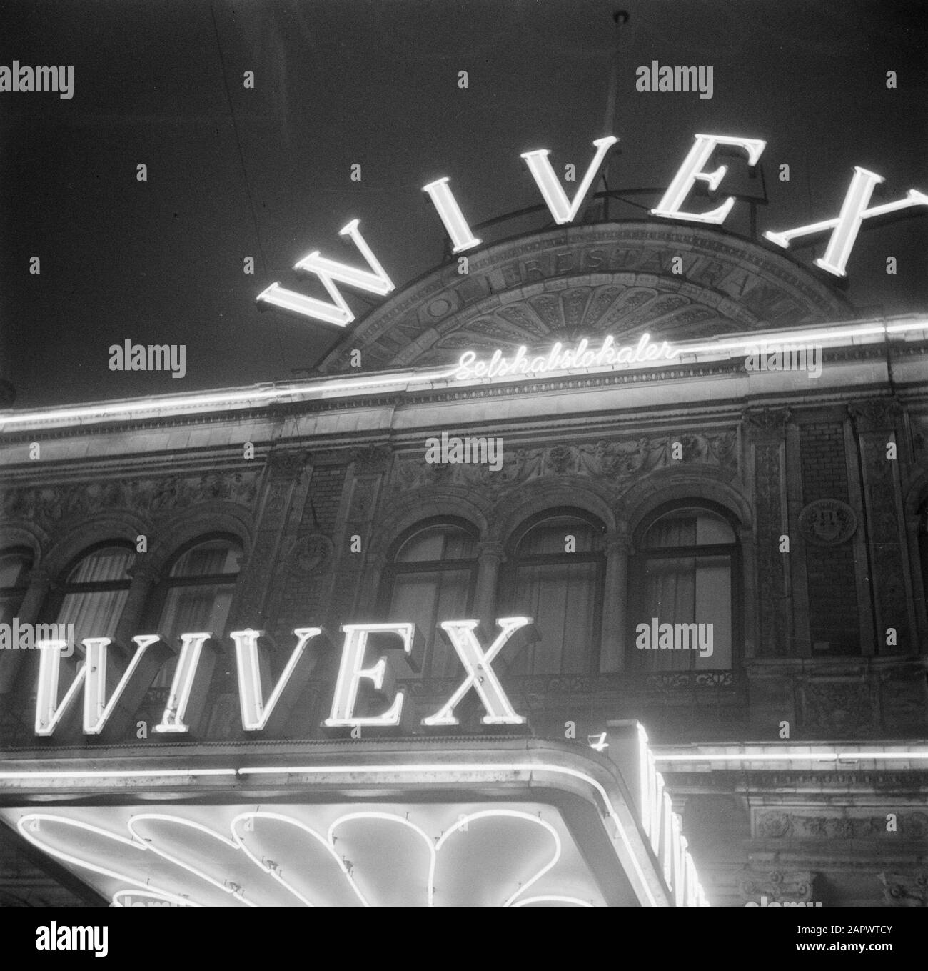 Restaurant Wivex located in the facade building of Tivoli park  Sign advertising to the building of restaurant Wivex Date: March 1954 Location: Denmark, Copenhagen Keywords: evening, lamps, advertising, restaurants, lighting Setting name: Wivex Stock Photo