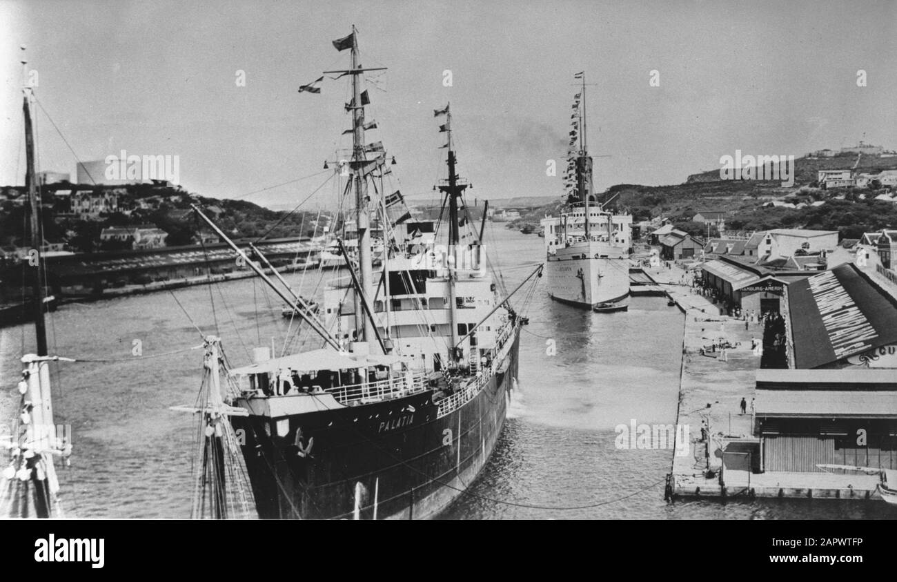 Wi [West Indies]/Anefo London series  [Dutch West Indies. Curacao. View of the St Annahaven of Willemstad. Right in the foreground the docks of the Curacao Trade Maatschappij and another complex of that company on the left side. In the hills the oil tanks for refueling ships in the Caracas bay] Annotation: Repronegative. The ship in the foreground is the ms Palatia, a German ship that operated a scheduled service of Hamburg Amerikanische Paketfahrt Actien-Gesellschaft (HAPAG) in the Caribbean from 1928 onwards. This ship was sold to the Soviet Union in 1940, then seized again by the Kriegsmari Stock Photo
