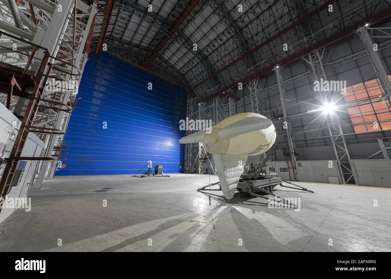 Aerostat on a mobile mooring platform inside an giant airship hangar huge blue gates Stock Photo
