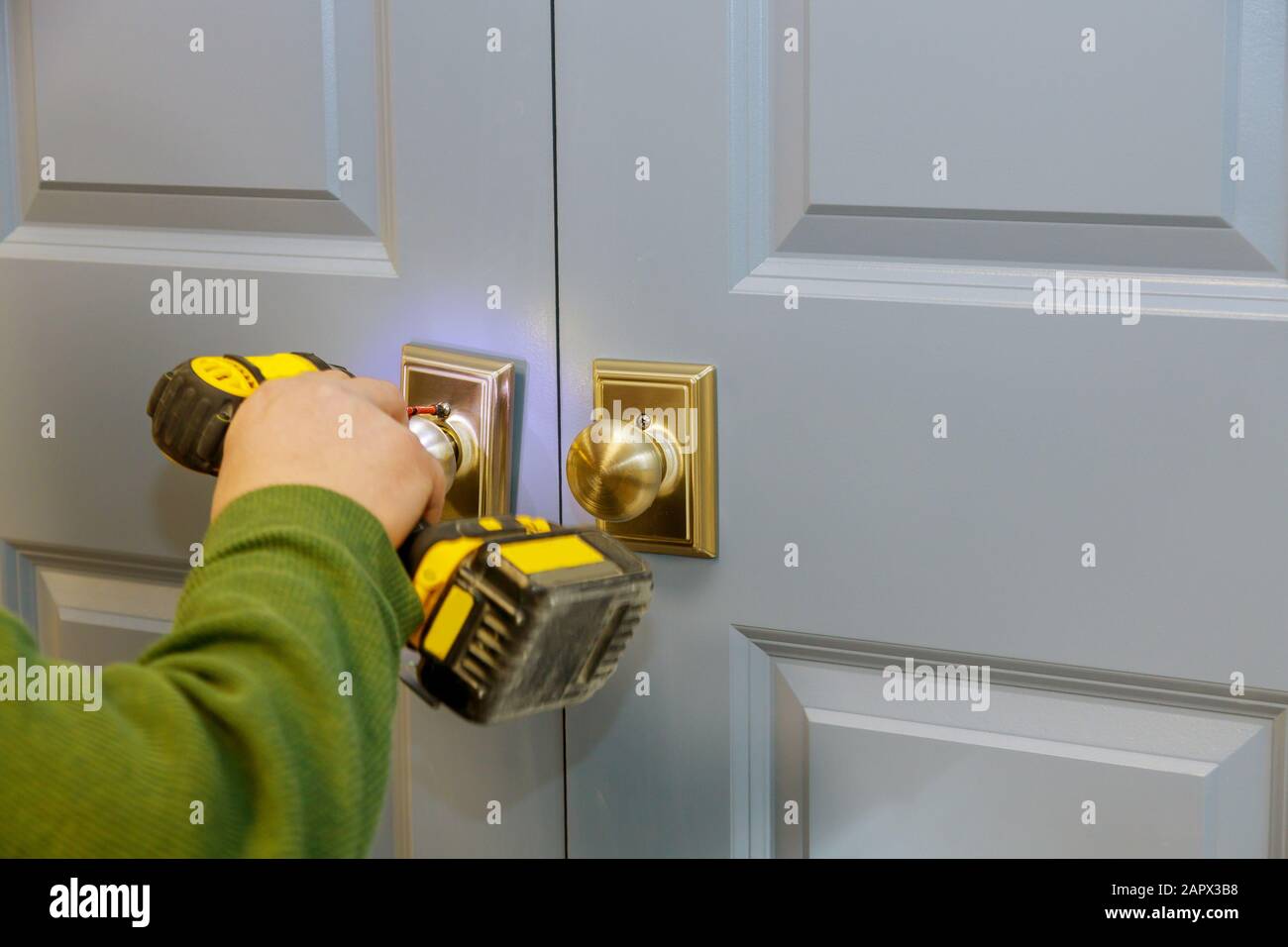 Installation of the door lock handyman using a screwdriver Stock Photo ...