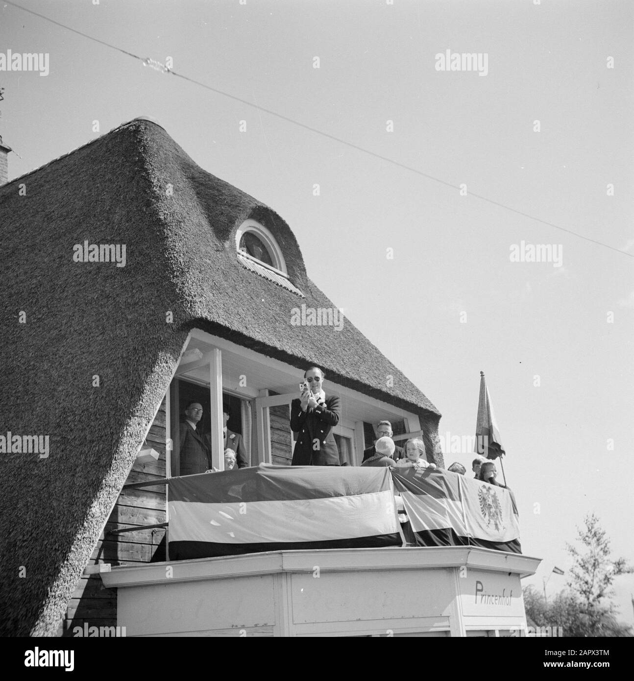 The princely family in Friesland  Prins Bernhard films from the balcony of Hotel Princenhof in Eernewoude Date: 1947 Location: Friesland, Tietsjerksteradeel Keywords: film cameras, royal house, princsen Personal name: Bernhard, prince Stock Photo