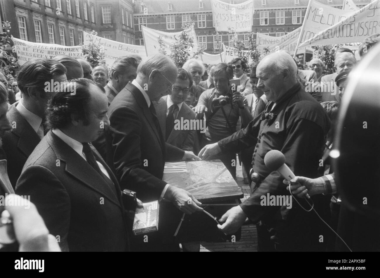 Protest sea fishermen against odds and catch distribution, Vondeling gets on Binnenhof casket haddock offered, left front Roels of the PVDA Date: May 10, 1976 Keywords: offers, crates, protests Stock Photo