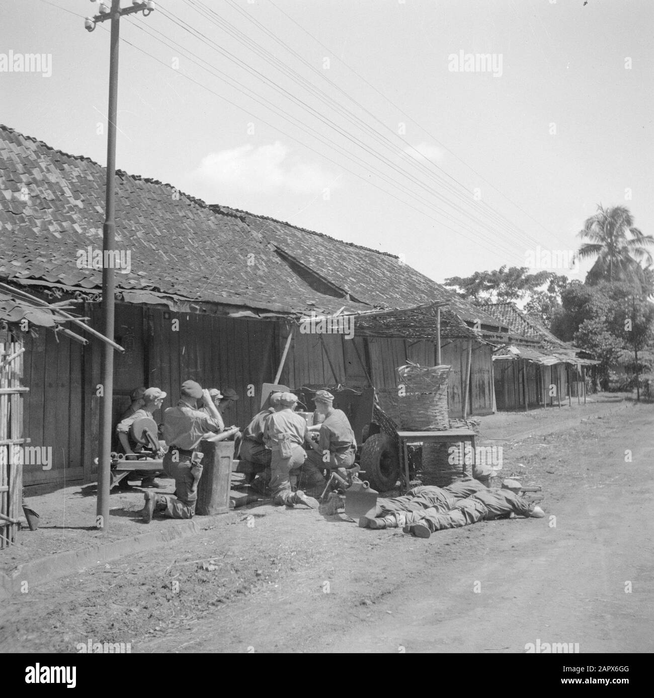 War volunteers in Malacca and Indonesia  Repair of light guns in a kampong Date: March 1946 Location: Indonesia, Indonesia, Java, Dutch East Indies Keywords: artillery, villages, military Stock Photo