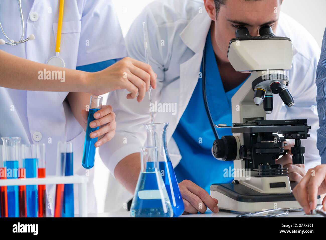 Group of scientists wearing lab coat working in laboratory while