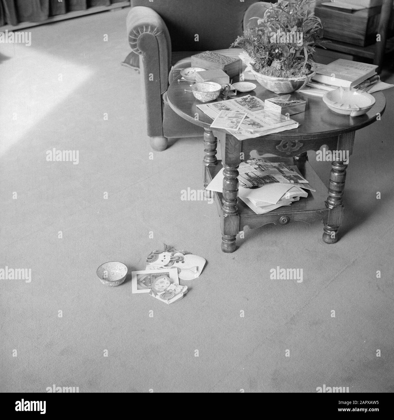 The royal family at palace Soestdijk  Coffee table with books and newspapers and armchair in the study of Princess Juliana Date: ca. 1947 Location: Baarn, Utrecht (province) Keywords: ashtraks, books, cookie drums, royal house, newspapers, plants, cigarette boxes, tables Stock Photo