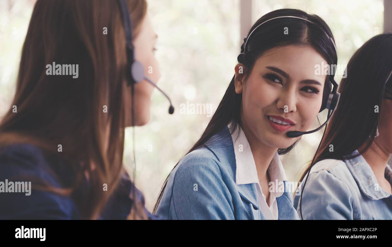 Customer support agent or call center with headset works on desktop