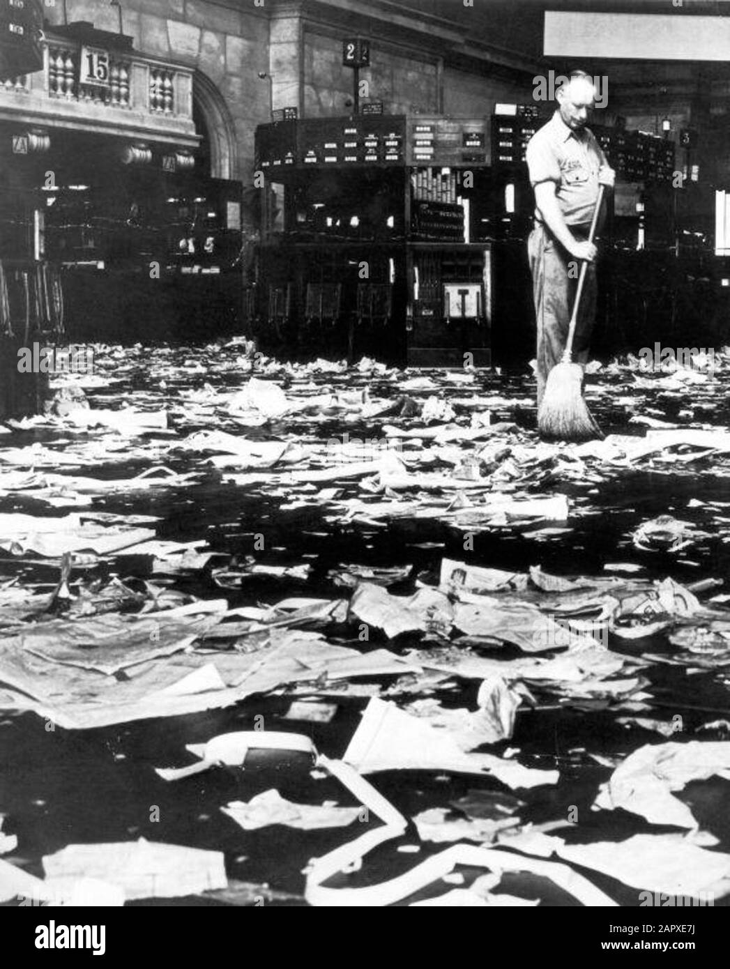 Savings City Photo, SFA001018144 The New York Stock Exchange in Wall Street after the crash, 1929: cleaner wipes the floor with a broom, filled with crumpled and torn newspapers and other paper. Stock Photo