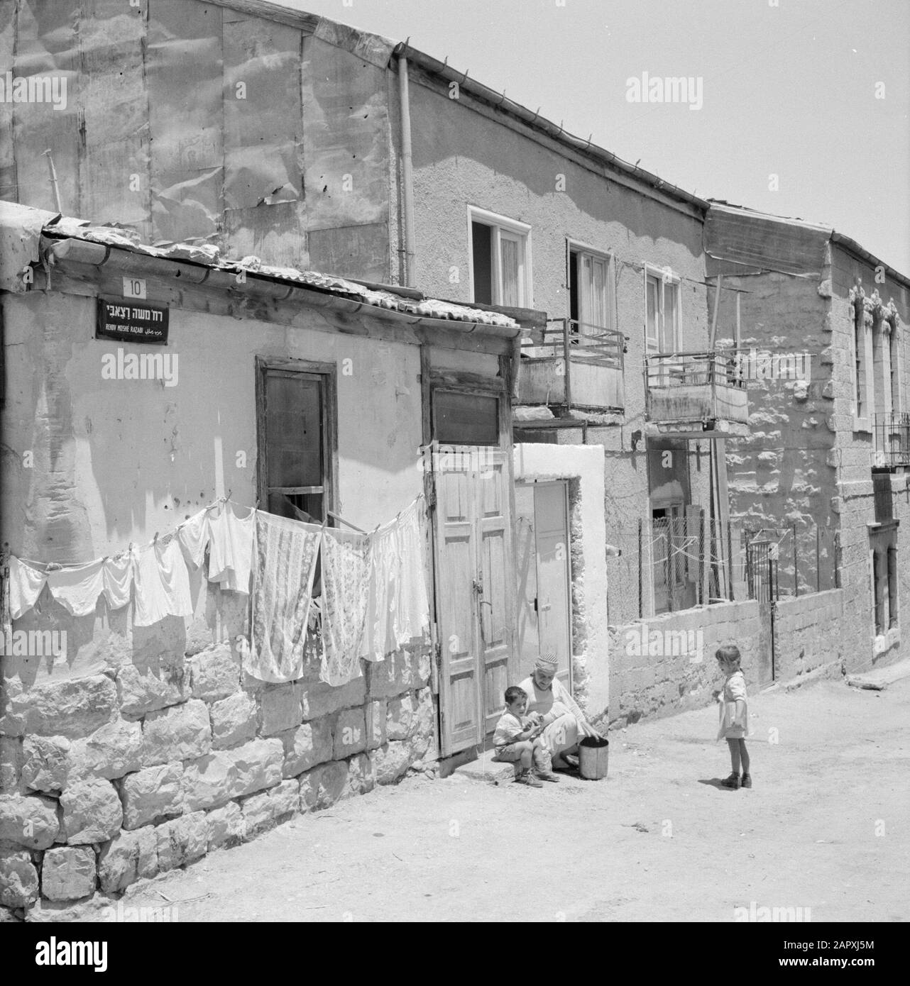 Israel 1964-1965: Jerusalem (Jerusalem), Mea Shearim  Street in the district of Mea Shearim with household activity Annotation: Mea Shearim, also called Meah Shearim or a hundred gates, is one of the oldest neighborhoods of Jerusalem. It was built from about 1870 by Hasidic Jews who lived in the Old Town until then. However, there was too little space and so they bought a piece of land northwest of the city. This land, a swamp area, was cultivated into land to build a new neighborhood: Meah Shearim. The district is known anno 2012 as the most extreme orthodox Jewish quarter in the world and is Stock Photo