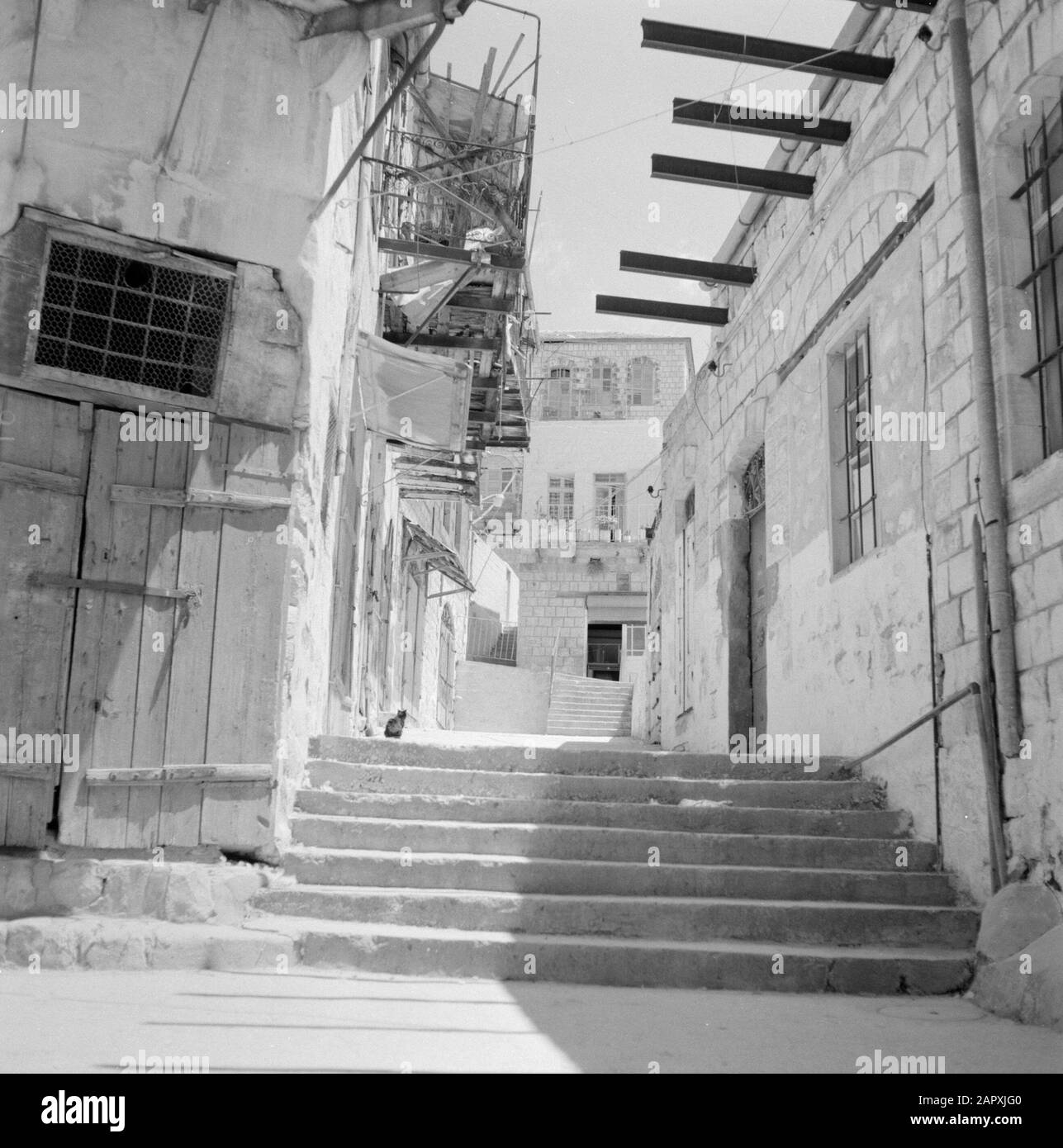 Street image in the artists' colony near Safad (Safed). Houses with wrought-iron balconies and on the right a wall containing excellent iron supports for a balcony and with a staircase in front of the street and a gate with skylight and double door Date: undated Location: Israel, Safad, Safed Keywords: balconies, iron, artists' colonies, gates, street images, stairs Stock Photo