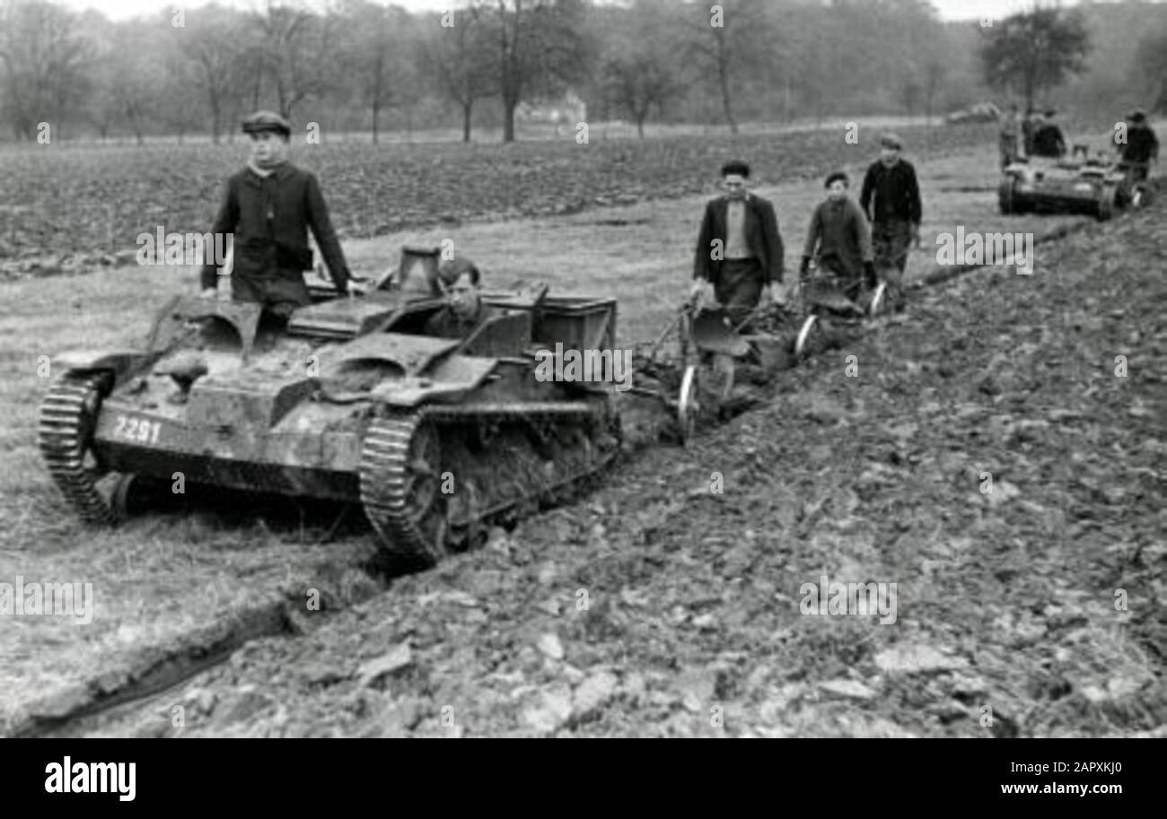 Spaarnestad Photo/SFA022804385 World War II. German soldiers in tankette help French farmers on land with plowing. France, 1941. Tankette: small tank exploited by Germans (Renault) which was used for various activities. Second World War. German soldiers in tankette (little tank) are helping French farmers plough their fields. France, 1941. [Tankette: little tank (Renault), captured by German forces and used for various tasks]. Stock Photo