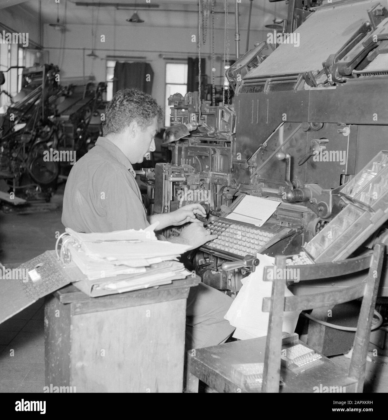 Israel 1964-1965: Tel Aviv, Dawar Printing,  Tel Aviv. Typographer working behind a linotype breeder in the printing house where the daily Dawar (Dvar) is printed Annotation: The Linotype is a regulating machine in which the functions of putting and casting are united. The machine was developed by a German immigrant in the US and produced from 1886 Date: 1964 Location: Israel, Tel Aviv Keywords: workers, printing, newspapers, machines, typographers, workshops Stock Photo