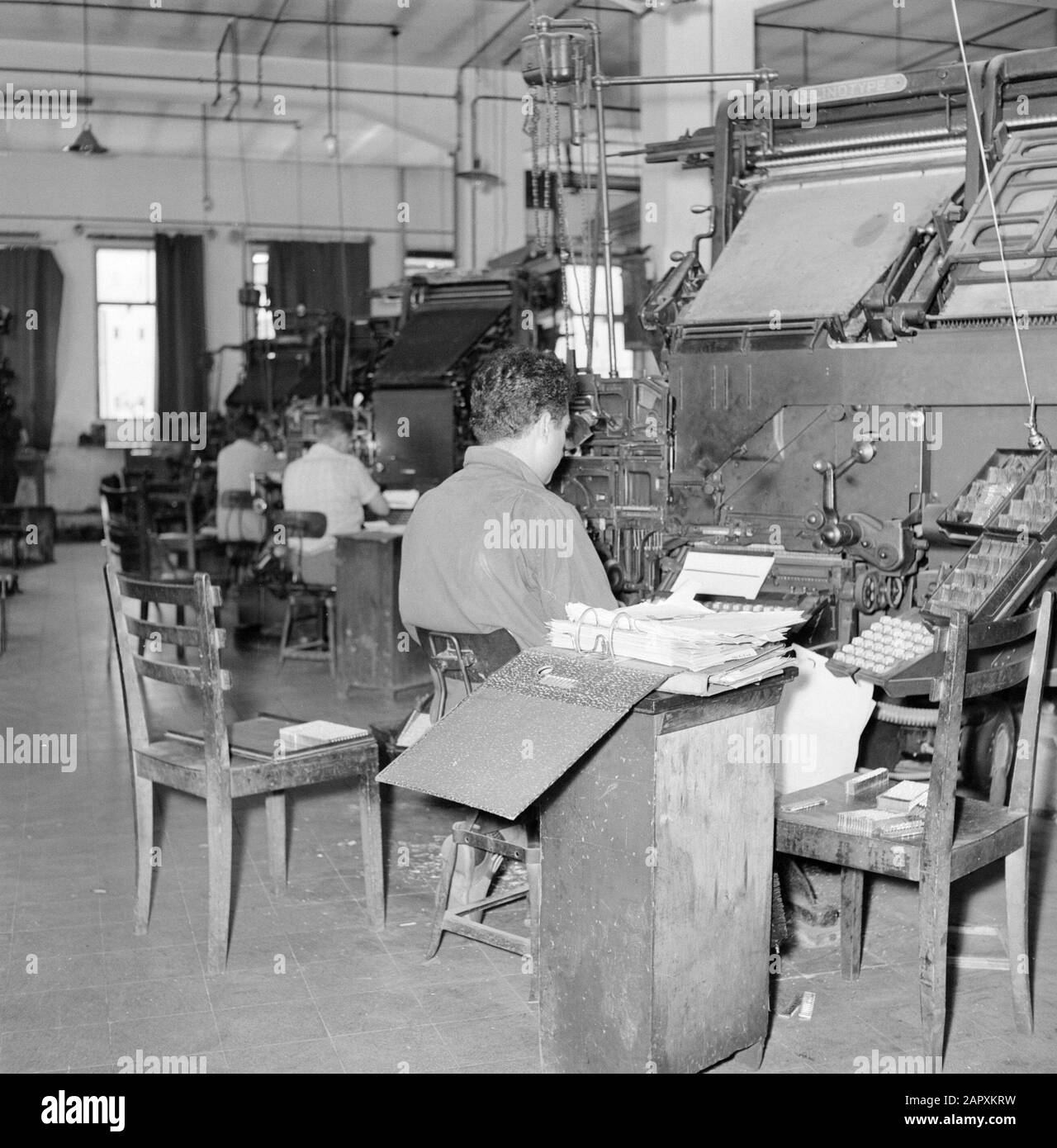 Israel 1964-1965: Tel Aviv, Dawar Printing,  Tel Aviv. Typographers working behind linotype setters in the printing house where the daily Dawar (Dvar) is printed Annotation: The Linotype is a regulating machine in which the functions of moving and casting are united. The machine was developed by a German immigrant in the US and produced from 1886 Date: 1964 Location: Israel, Tel Aviv Keywords: workers, printing, newspapers, machines, typographers, workshops Stock Photo