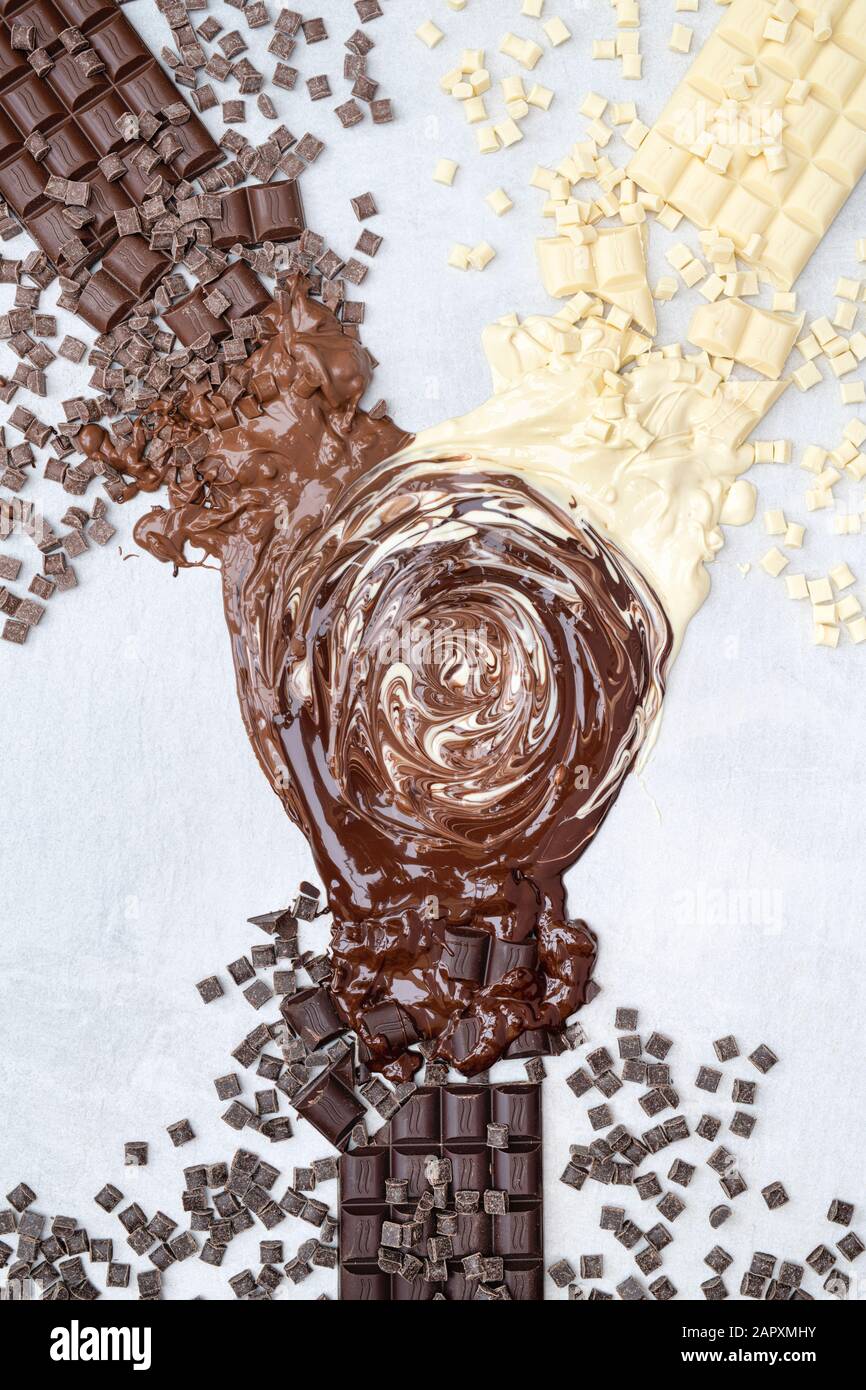 Assorted bars of milk, dark and white chocolate melted together in the centre pattern Stock Photo