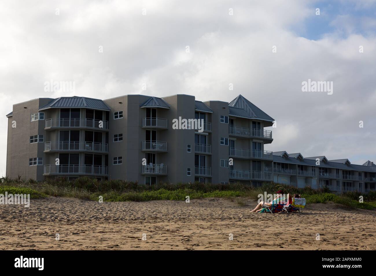 A couple faces away from the water as they relax at Stuart Beach on Hutchinson Island, Florida, USA. Stock Photo