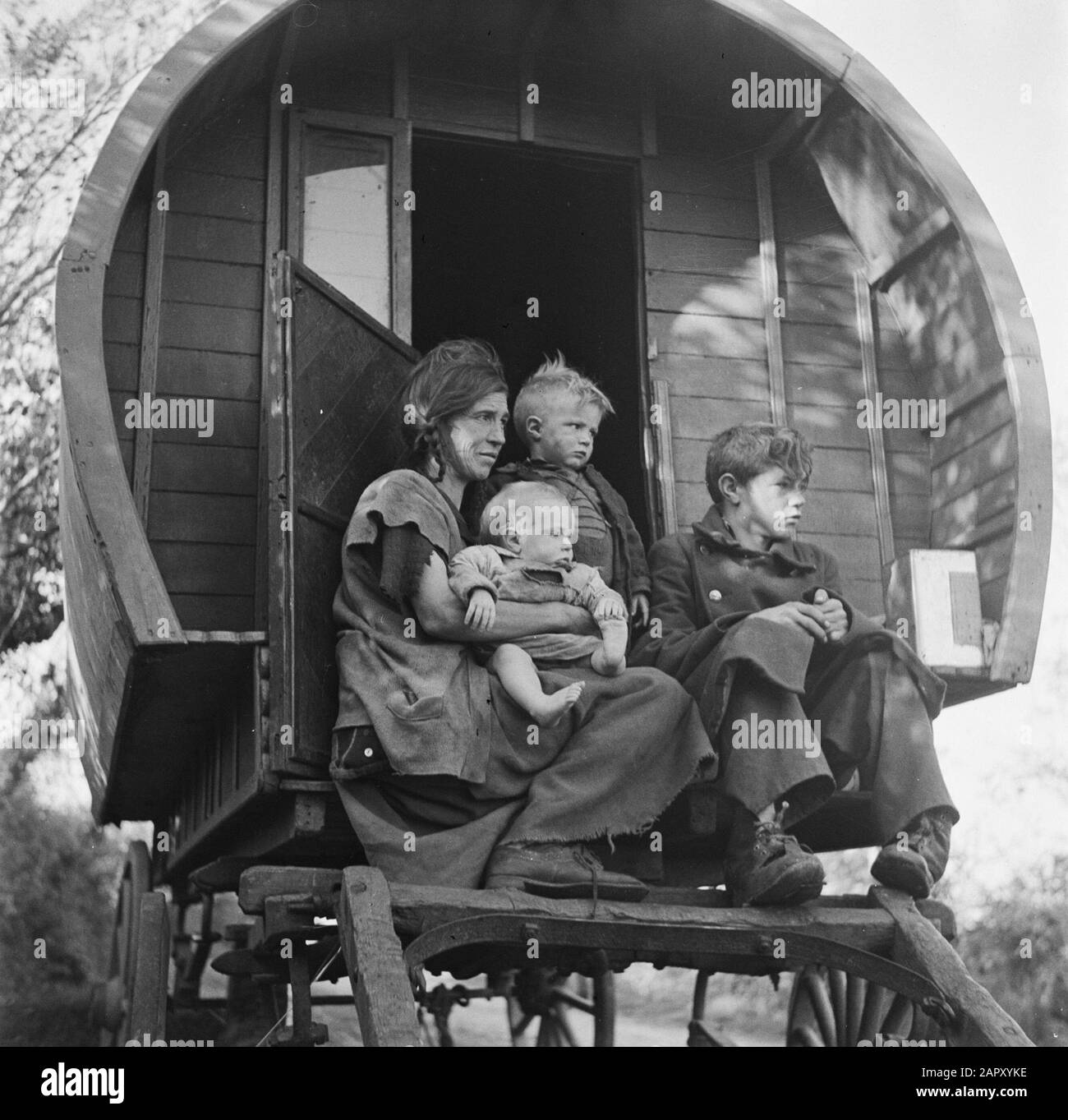 Tinkers in Ireland  Woman with children on the goat of a covered wagon Annotation: 'Tinker' is the English word for ketellapper Date: January 1, 1930 Location: Ireland Keywords: families, covered cars, Gypsies Stock Photo