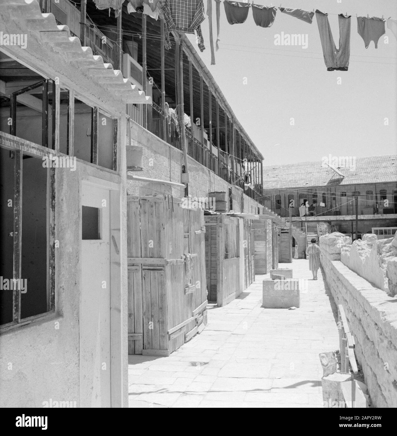 Israel 1964-1965: Jerusalem (Jerusalem), Mea Shearim  View of a courtyard with houses at a gallery and household activity Annotation: Mea Shearim, also called Meah Shearim or a hundred gates, is one of the oldest neighborhoods of Jerusalem. It was built from about 1870 by Hasidic Jews who lived in the Old Town until then. However, there was too little space and so they bought a piece of land northwest of the city. This land, a swamp area, was cultivated into land to build a new neighborhood: Meah Shearim. The district is known anno 2012 as the most extreme orthodox Jewish quarter in the world Stock Photo