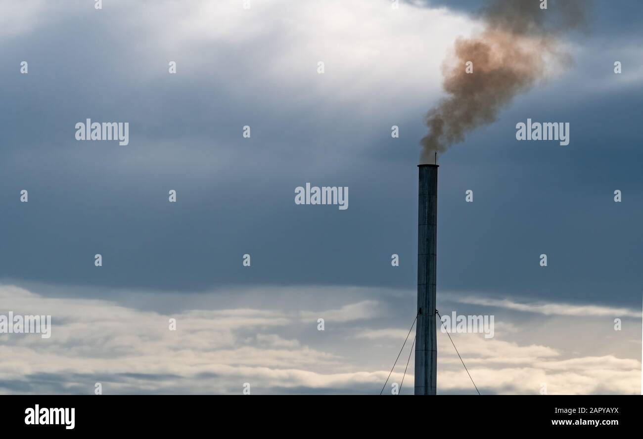 Air pollution from factory. Smoke from chimney of industrial pipe on sunset sky. Global warming problem concept. Bad air quality. Air pollutant Stock Photo