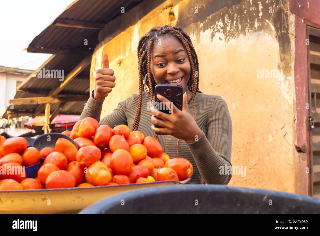 young black lady using her smartphone in the market Stock Photo