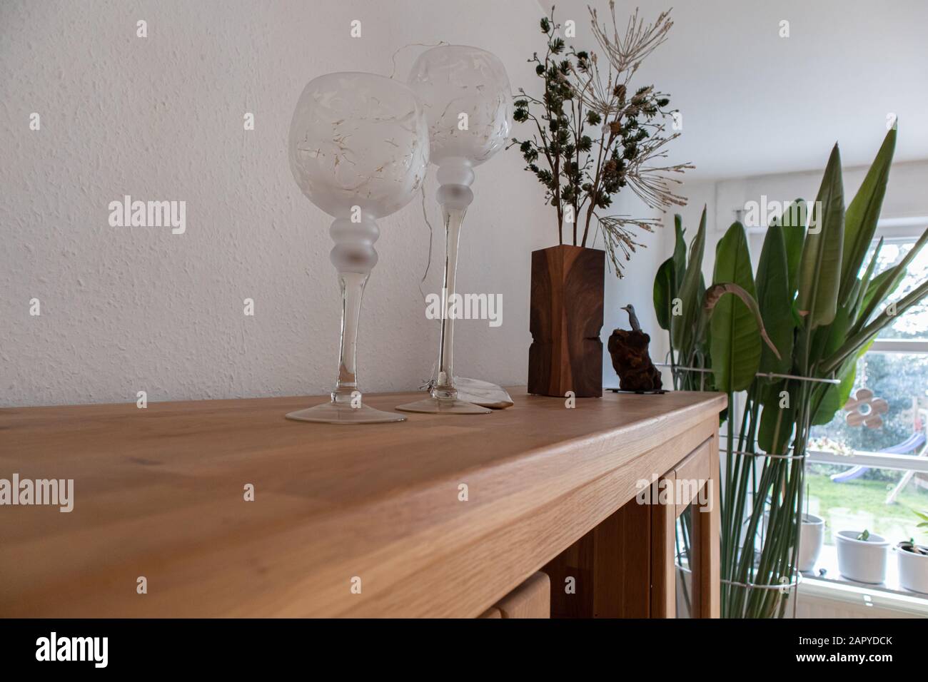 A Landscape Shot Of Two Large Glassware Decor A Brown Wooden Vase