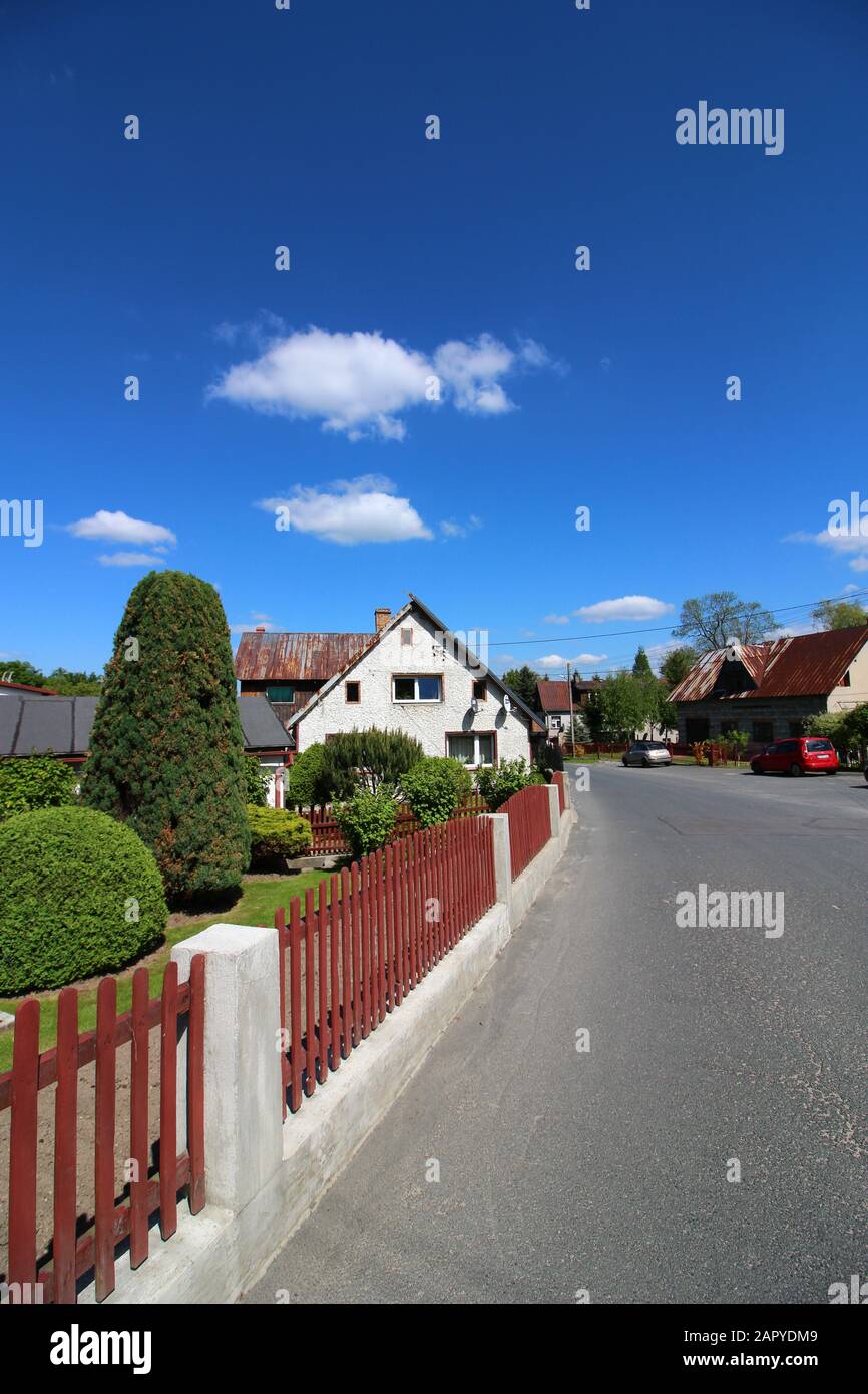 Vertical shot of a street of houses with green shrubs inside the red ...