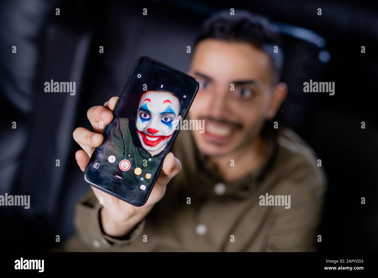 Hand of young smiling man holding smartphone while using multimedia ...