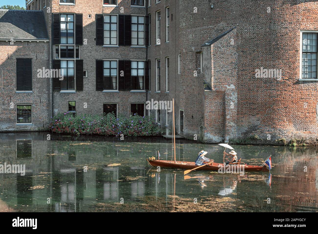Rozendaal, Netherlands, 25 August 2019:  Musician plays on a harp in a rowing boat sailing on the castle moat of Rosendael castle Stock Photo