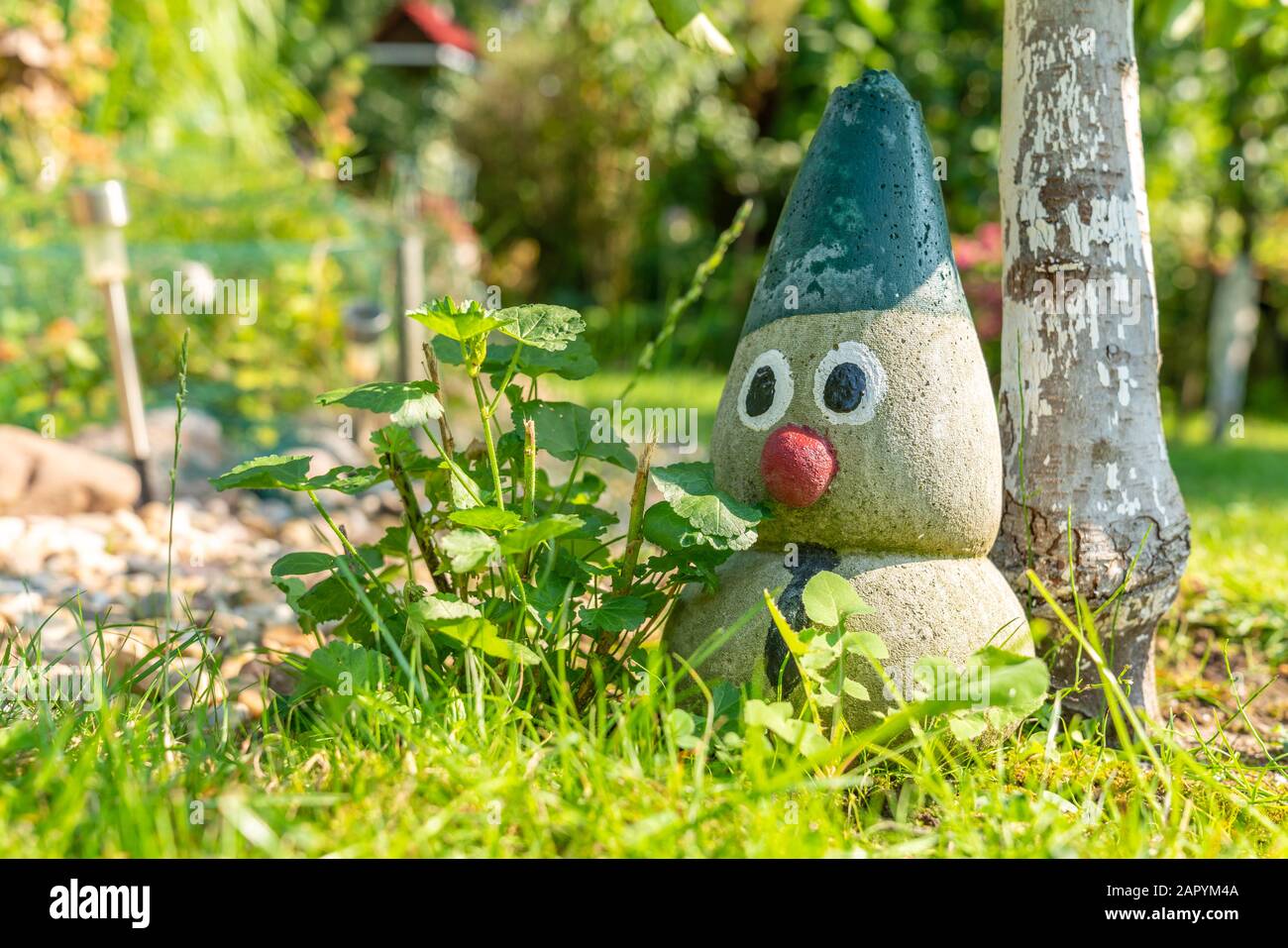 a decorative garden gnome in a house garden Stock Photo