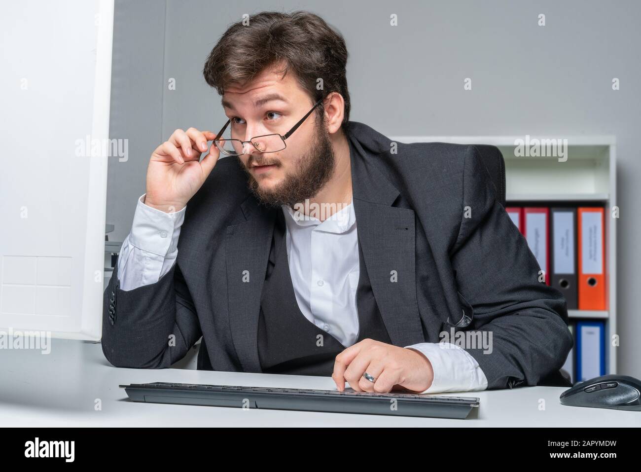 an employed has trouble reading the monitor content and looks over his