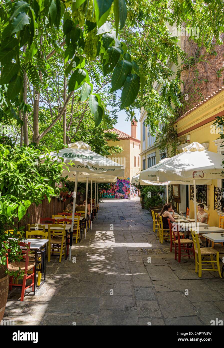 Tree framed street with traditional Greek Taverna tables and chairs in the streets of old Plaka, Athens, Greece Stock Photo