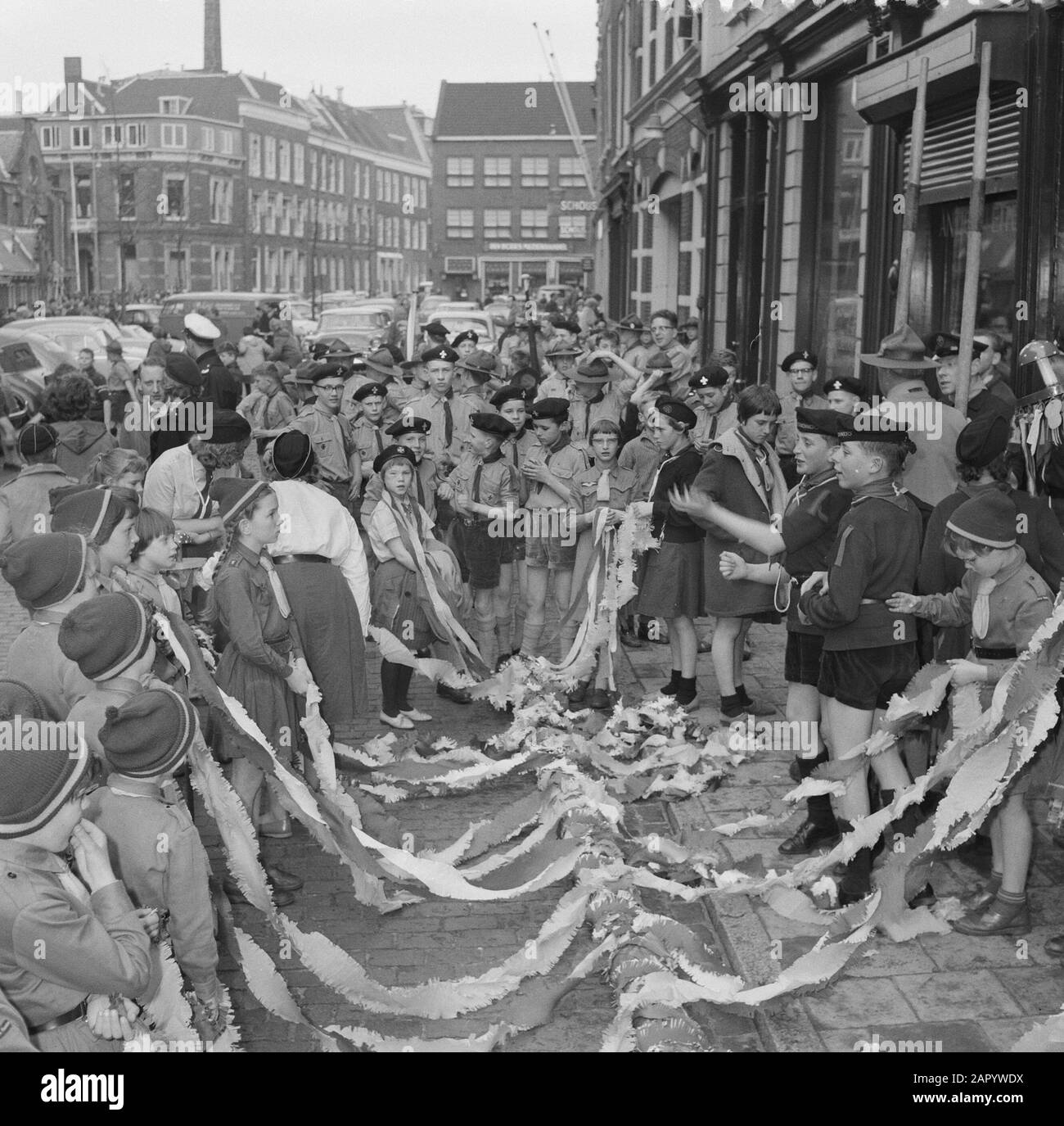 Heitje voor een Karweitje in Haarlem. Boy Scouts carry pole for Technical University of Applied Sciences Date: April 6, 1961 Location: Haarlem Keywords: Scouts, Technical Hogescholen Stock Photo
