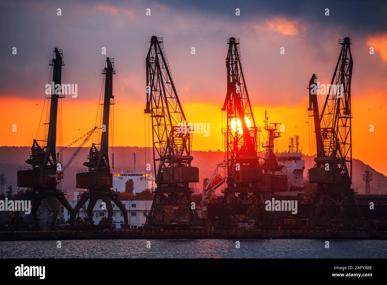 Colorful sunset over sea port and industrial cranes, Varna, Bulgaria Stock Photo