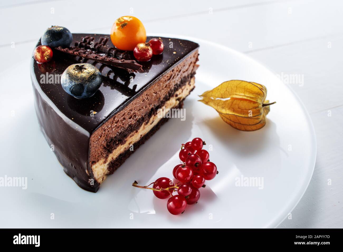 Chocolate cake with decoration and fruits as background Stock Photo - Alamy