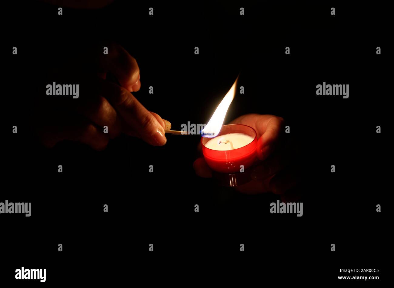 lighting a devotional candle in a church Stock Photo