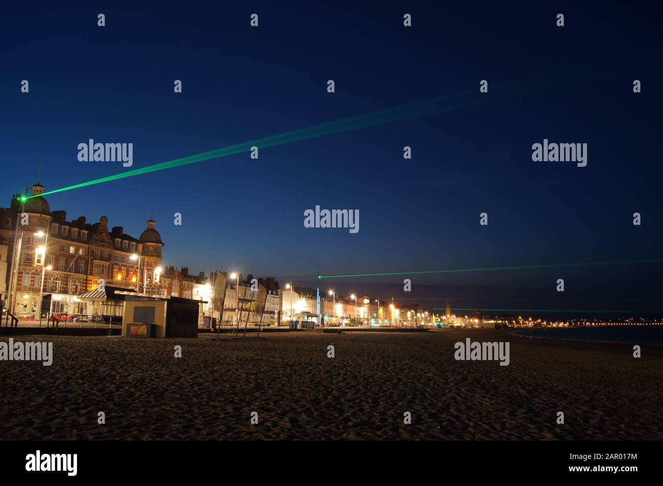 Green lasers on a sea front in Weymouth, Dorset. Stock Photo
