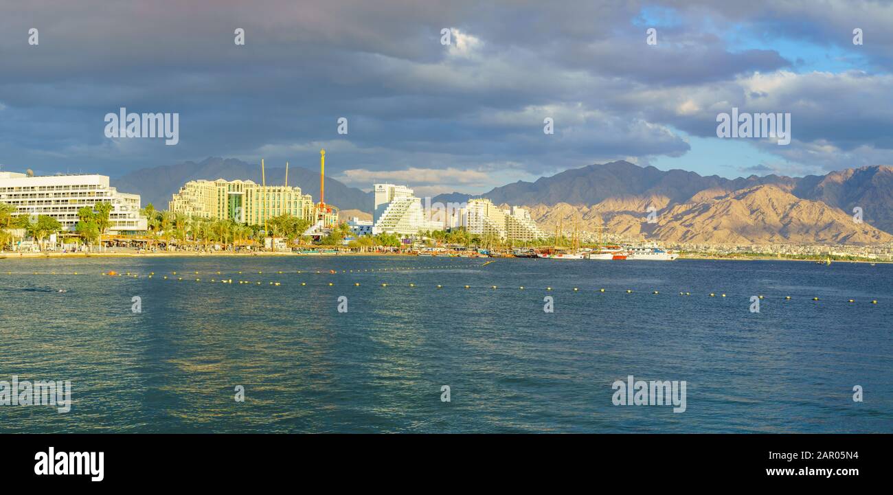Eilat, Israel - January 17, 2020: Panoramic view of the coastline, promenade and hotels, with visitors and Aqaba (Jordan) in the background. Eilat is Stock Photo