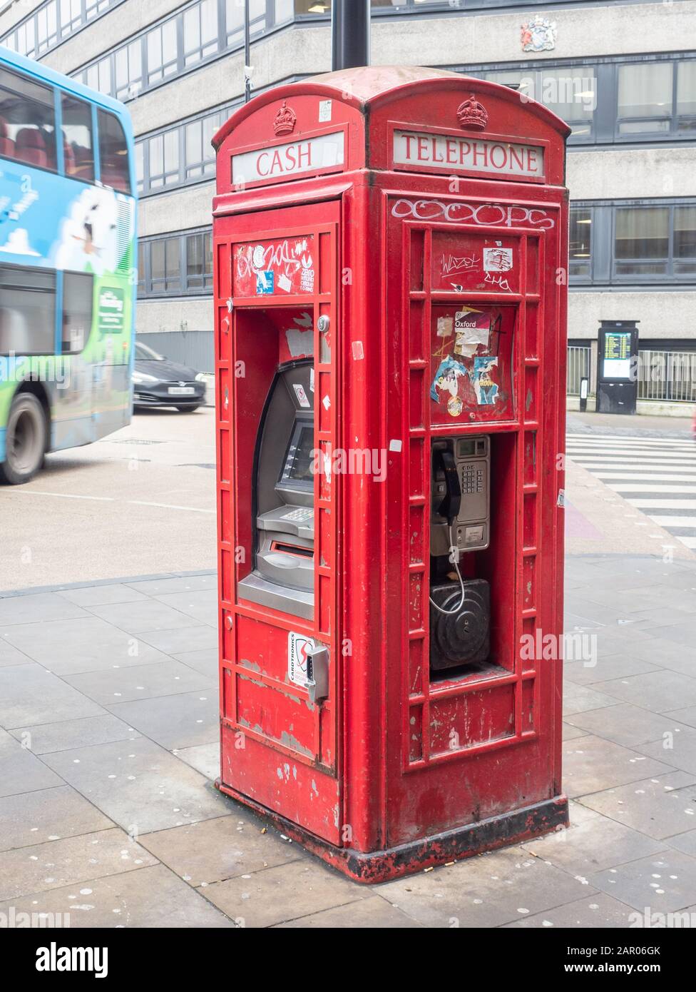 Red phone box with cash machine in New Road/Castle Street, Oxford Stock Photo