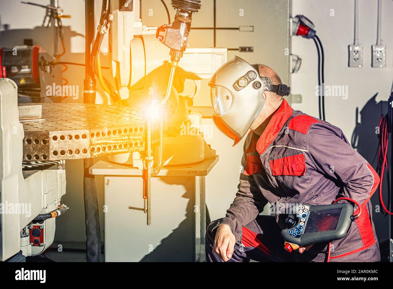 Engineers use remote control of robotic welding on smart factory, industry 4.0 in production line manufacturer factory Stock Photo