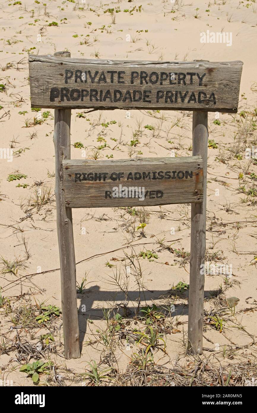 Private property sign on the beach with gullfeed (Scaevola plumieri), Ponta Malongane, Mozambique. Stock Photo