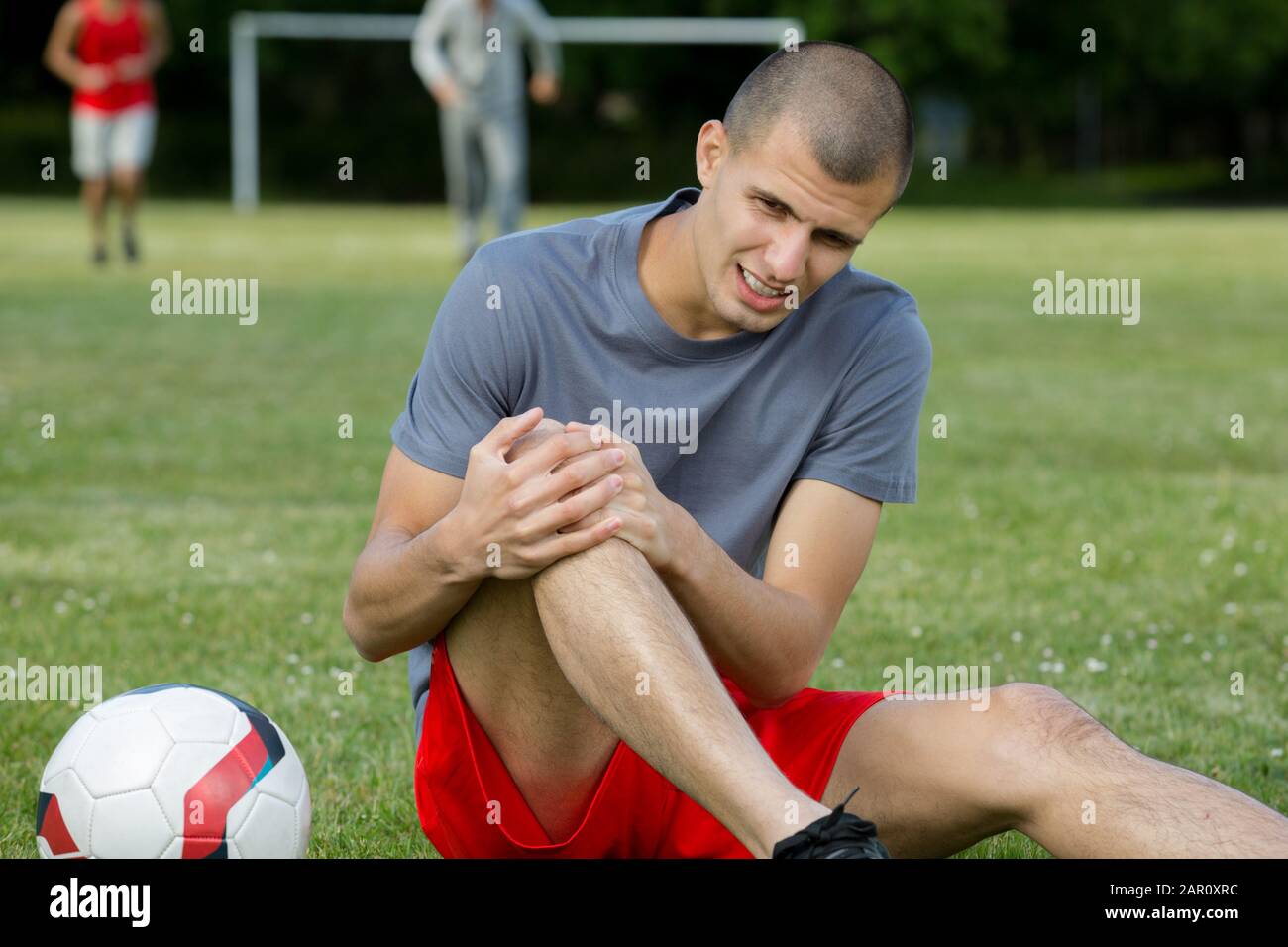man applying suffering with a leg injury Stock Photo - Alamy