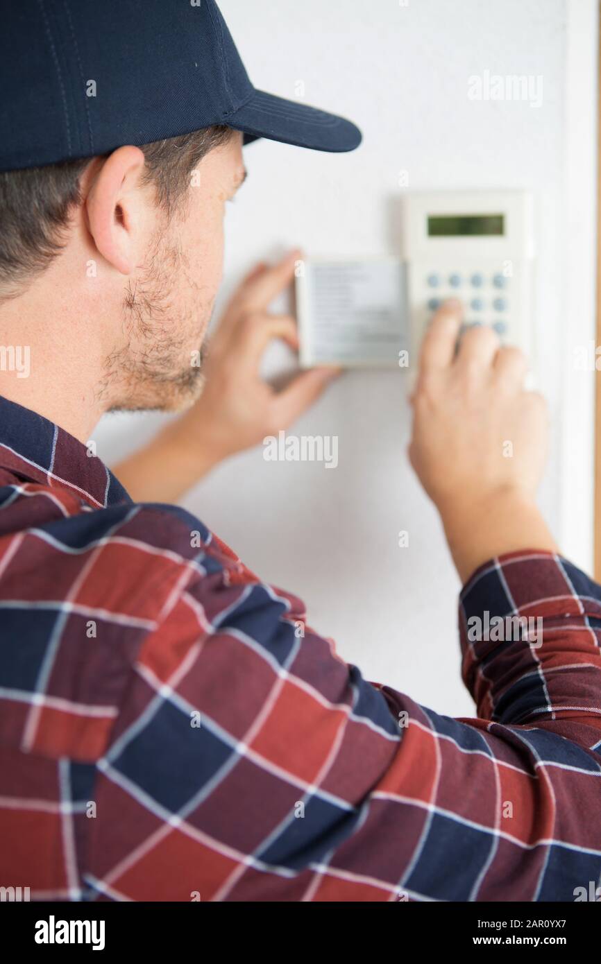 thermostat inspection and programming performed by hvac technician Stock Photo